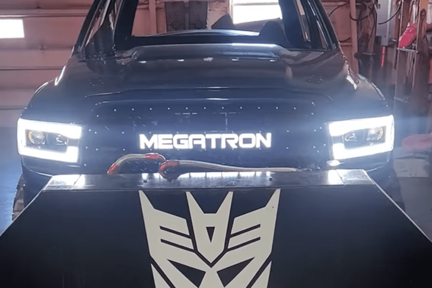 Megatron black vehicle with headlights on